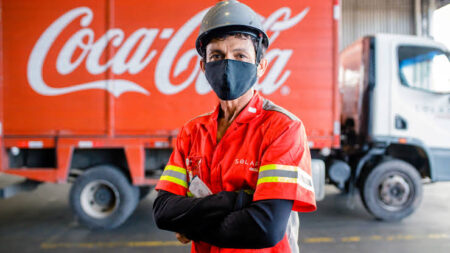 Homem em frente ao caminhão da coca-cola