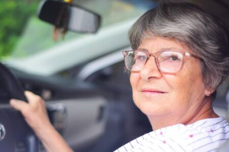 idosa com óculos no volante