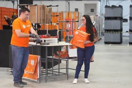 Homem e mulher em centro logístico da Shopee