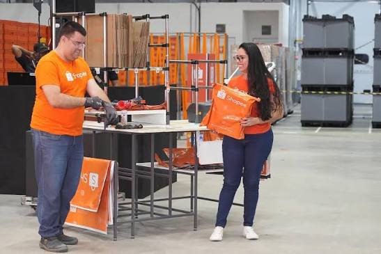 Homem e mulher em centro logístico da Shopee