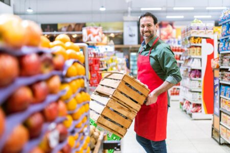 Homem com carrinho e mercadorias no mercado